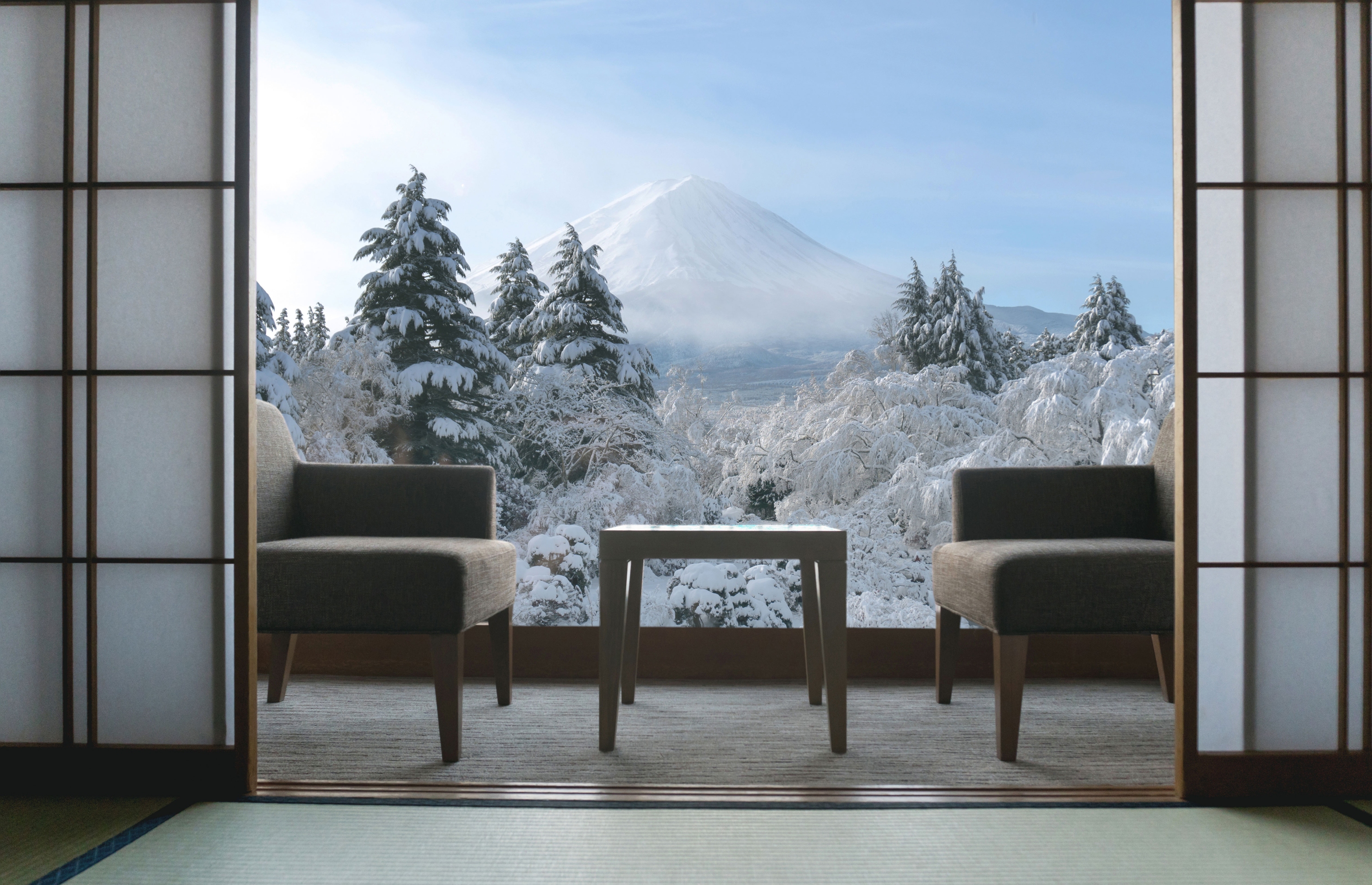 Ryokan suite with open shoji screens overlooking snowy Mount Fuji